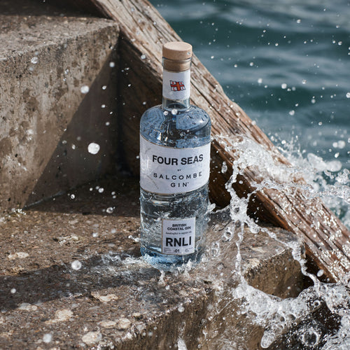 A bottle of Salcombe gin on a harbour wall