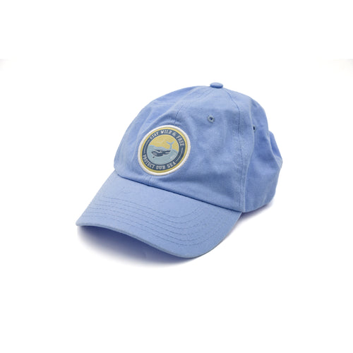 Kid's RNLI Stay Wild Cap, Blue. A light blue baseball cap for kids. With a circular embroidered logo on the front that features a whale in the ocean.