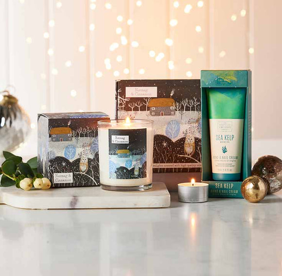  Candle, gift box, and skincare products on a table with a warm, blurred background 