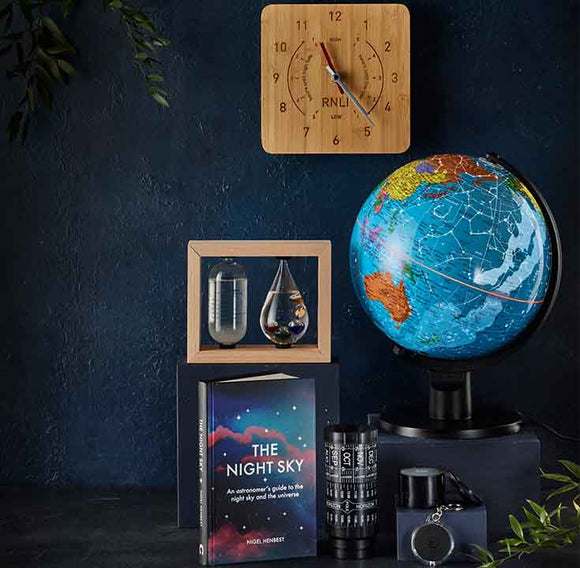  Globe, book titled 'The Night Sky', Stellarscope and other decorative items on a dark background 