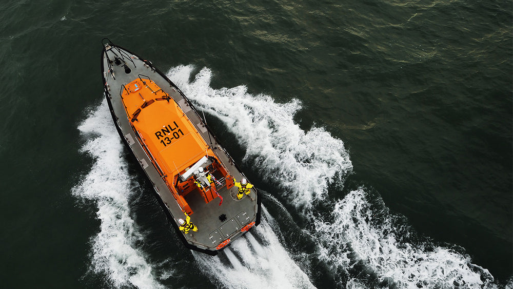  Orange RNLI 13-01 Shannon-class lifeboat speeding across dark water 