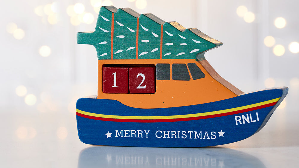  Decorative Christmas boat Calendar with 'Merry Christmas' and 'RNLI' text on a light background. 