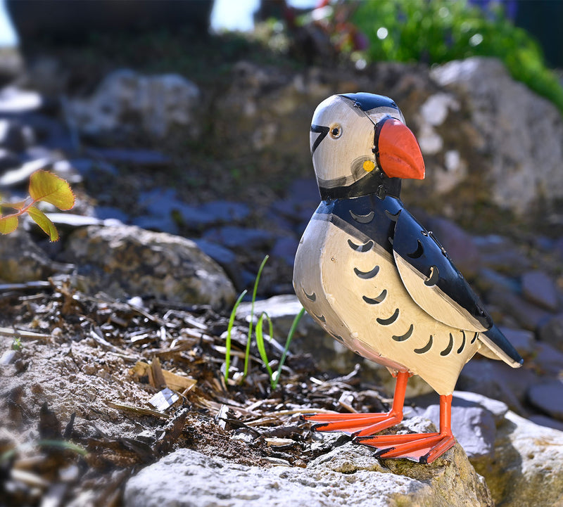   A Puffin tealight holder stands out on some garden rocks. 