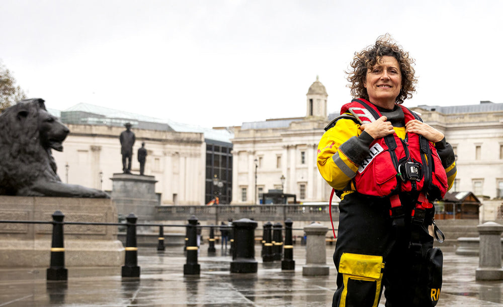  RNLI Crew member standing in the foreground of a city 