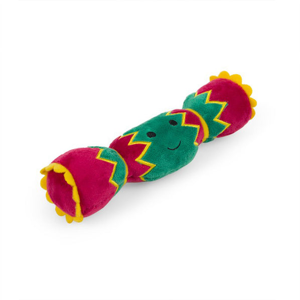 A plush dog toy in the shape of a Christmas cracker in red, green and yellow. 