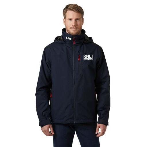 A man wearing a waterproof Helly Hansen jacket in navy with contrasting white logos. 