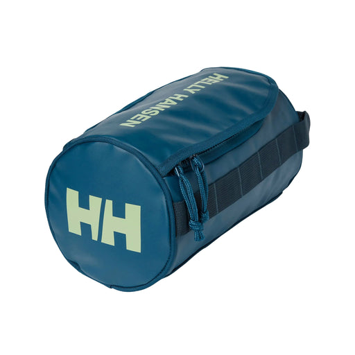A duffle-bag-shaped wash bag in a deep blue colour. WIth a large zip compartment on the top and a carry handle. 