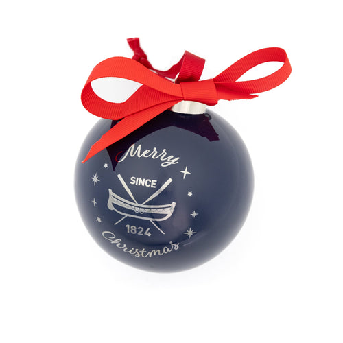The reverse side of a navy bauble with a print of a lifeboat and oars and the words, "merry Christmas".