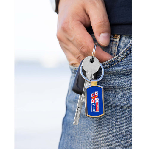 A man holding a set of keys with the RNLI Membership Keyring in the front.
