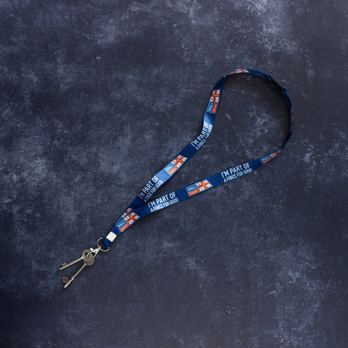 A navy RNLI Membership Lanyard laid out on dark surface. There's a set of metal keys clipped to the end.