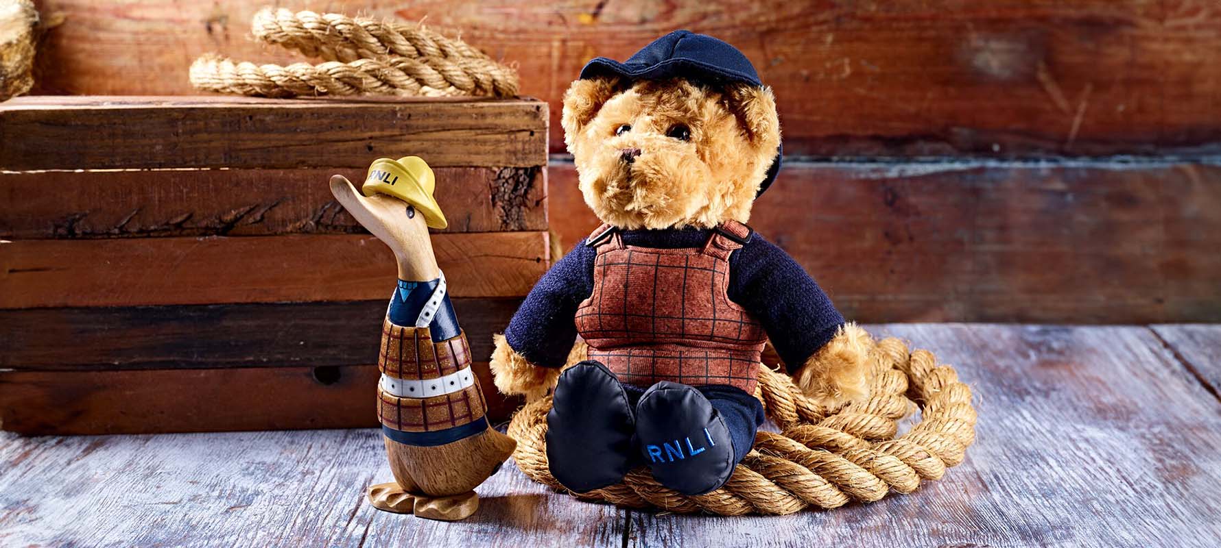 Wooden duck and teddybear in RNLI historic cork lifejackets.